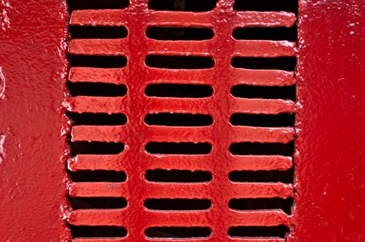 Old metal lattice with vents, painted with red paint