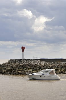 Leisure Boat in Front of a Jetty with a Cloudy Sky