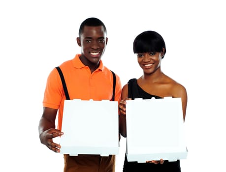 Beautiful young couple posing with open pizza boxes