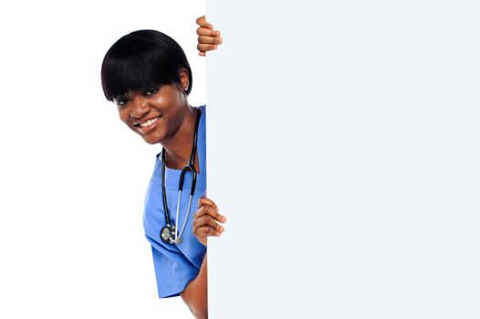 Female doctor holding long blank banner ad isolated over white background