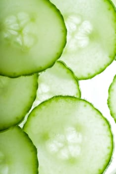 Sliced cucumber circles thrown on white