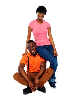 Woman in casuals sitting on mans shoulder. Happy african love couple