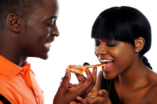 Beautiful african couple eating pizza isolated over white, closeup shot