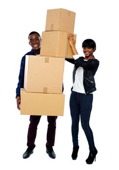 Attractive young couple standing with cardboard boxes. Smiling at camera