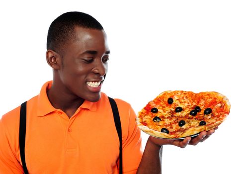 Smiling young black man holding yummy pizza against white background