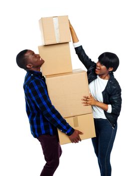 Teenage couple with cardboard boxes. Girl trying to make stack high