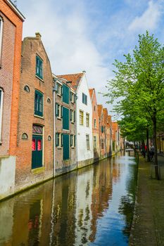 Typical dutch houses reflected in water on a sunny spring day. Vertical view