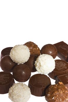 appetizing chocolate candies with a nut and coconut are sparse on a white background