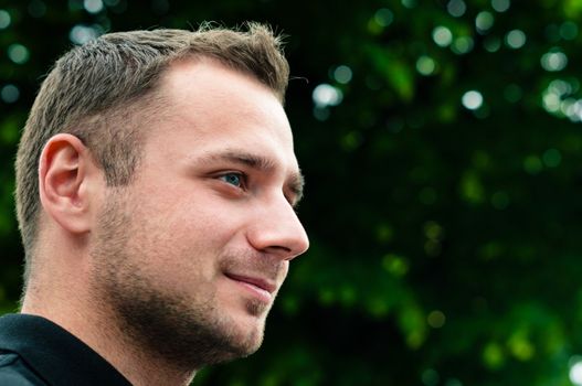 Attractive man head profile with green tree on background