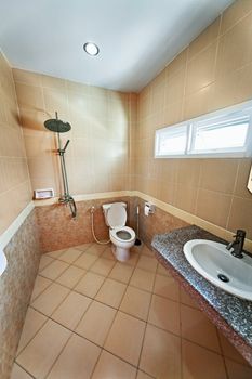 The interior of modern bathroom with shower. Beige tiles
