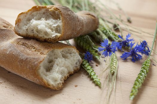 fresh french baguette bread with cornflowers and wheat