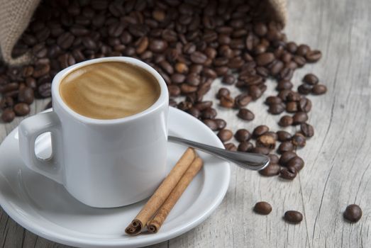 Still life about coffee with a delicious  espresso and some coffee beans and cinnamon.