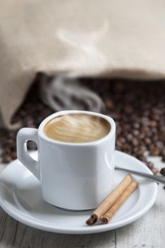 Still life about coffee with a delicious  espresso and some coffee beans and cinnamon.