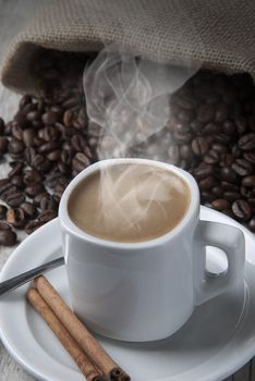 Still life about coffee with a delicious  espresso and some coffee beans and cinnamon.