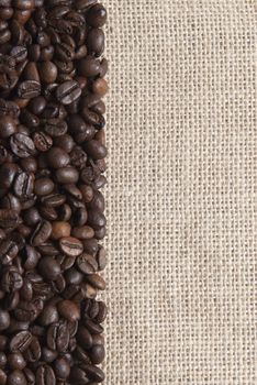 Background of burlap and coffee beans with a copy space.