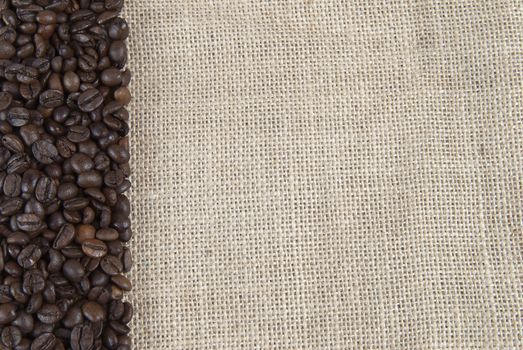 Background of burlap and coffee beans with a copy space.