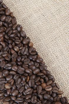 Background of burlap and coffee beans with a copy space.