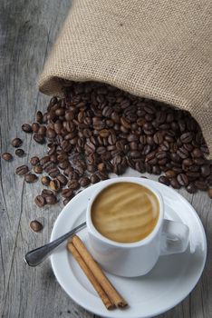 Still life about coffee with a delicious  espresso and some coffee beans and cinnamon.