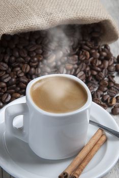 Still life about coffee with a delicious  espresso and some coffee beans and cinnamon.