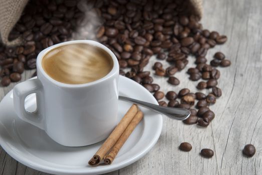 Still life about coffee with a delicious  espresso and some coffee beans and cinnamon.