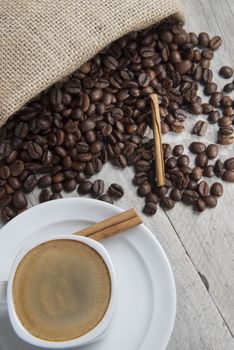 Still life about coffee with a delicious  espresso and some coffee beans and cinnamon.