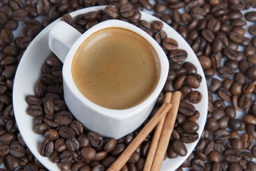 Still life about coffee with a delicious  espresso and some coffee beans and cinnamon.