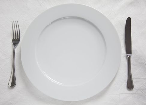 Dinner Plate, Knife and Fork on linnen cloth