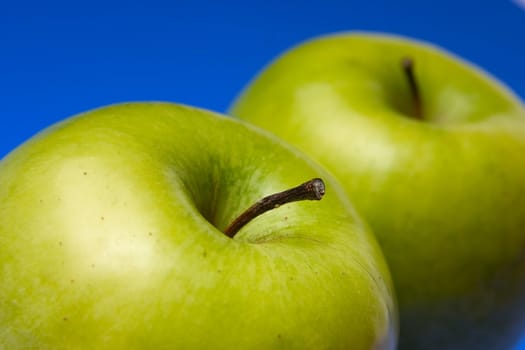 appetizing apples of green color on a blue background