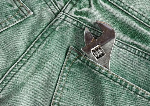 Green jeans pocket with old tool