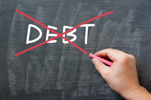 Debt written on a smudged blackboard, being crossed out