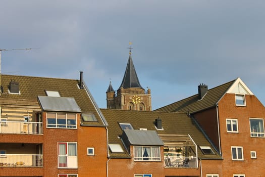 The facade of a modern building on the background of the church in Gorinchem, Netherlands