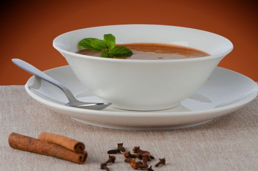 Chocolate mousse ou a white mug with mint leaves.
