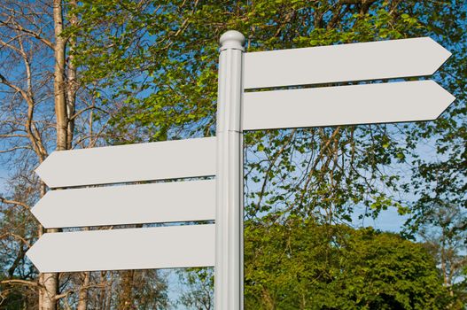 empty multidirectional sign against a nature background (boards isolated on grey)