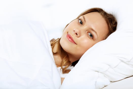 Portrait of a young smiling girl in bed