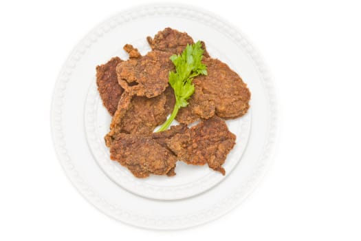 Chicken cutlet served on a plate and decorated with parsley leaf