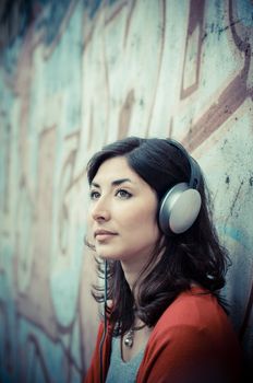 Beautiful stylish woman listening to music in the street 