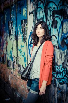 Beautiful stylish woman listening to music in the street 