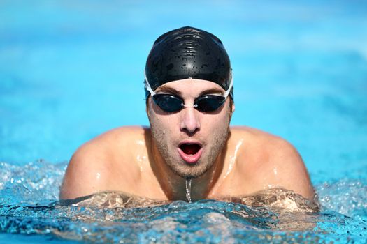 Swimming - male swimmer swimming breaststroke. Caucasian man doing breast swimming in pool wearing swimming cap and swim goggles.