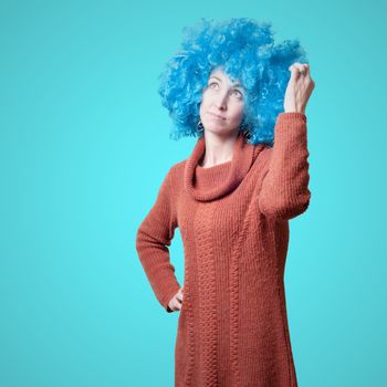 beautiful girl with curly blue wig and turtleneck on colorful background