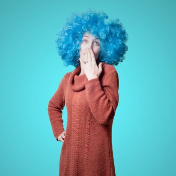 beautiful girl with curly blue wig and turtleneck on colorful background