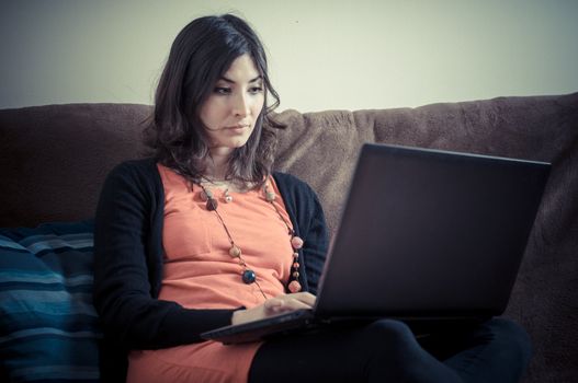 woman at home using notebook on couch
