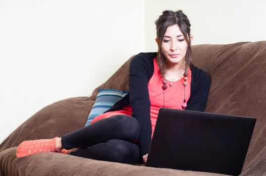 woman at home using notebook on couch