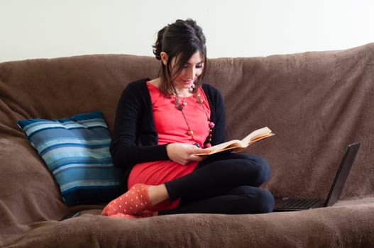 woman at home reading book on couch