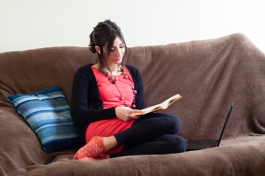 woman at home reading book on couch