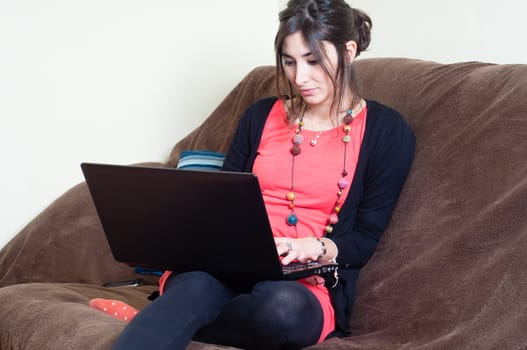woman at home using notebook on couch