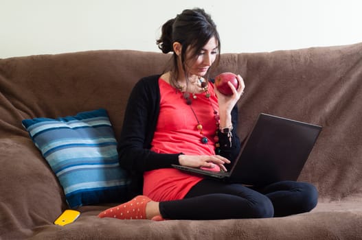 woman at home using notebook on couch