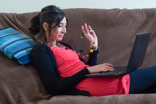 woman at home using notebook on couch
