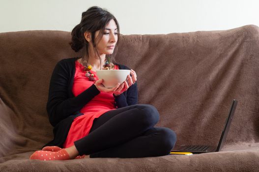 woman at home using notebook on couch