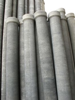 Stack of many asbestos pipes on white background