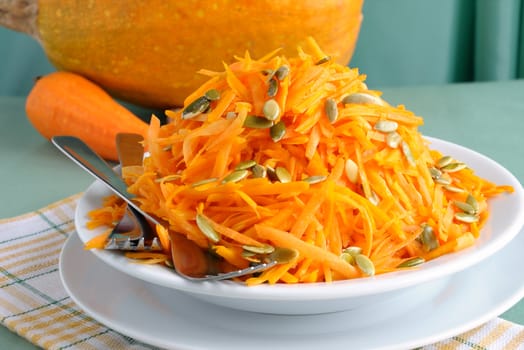 Salad of fresh pumpkin and carrot with pumpkin seeds